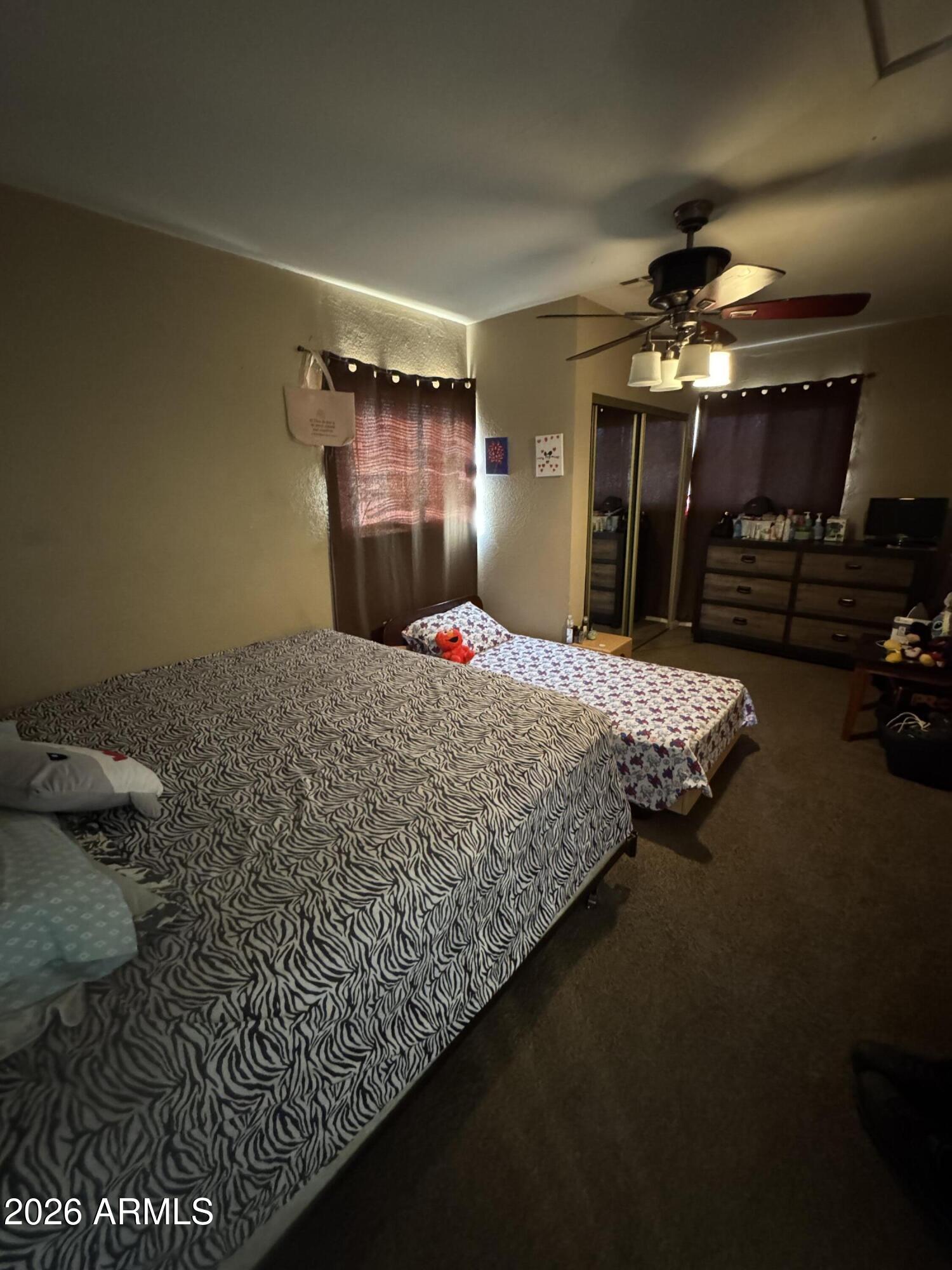 6313 West Osborn Road Phoenix, AZ 85033 - Photo 6 of 12 a bedroom with a bed and a chandelier