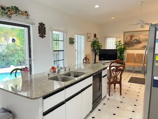 a kitchen with stainless steel appliances granite countertop a refrigerator sink and stove