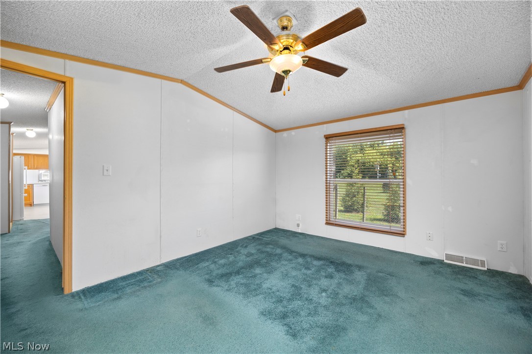35157 Center Ridge Road, Unit 150 North Ridgeville, OH 44039 - Photo 5 of 33 Interior room featuring a ceiling fan with integrated lighting, a window with horizontal blinds, and paneled walls with wood-finish trim