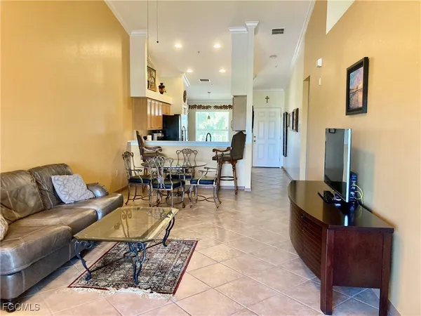 a living room with furniture kitchen view and a chandelier
