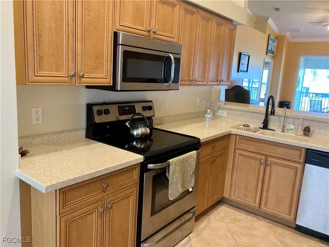a kitchen with stainless steel appliances a stove microwave and sink