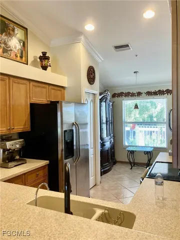 a living room with stainless steel appliances furniture a rug and a large window