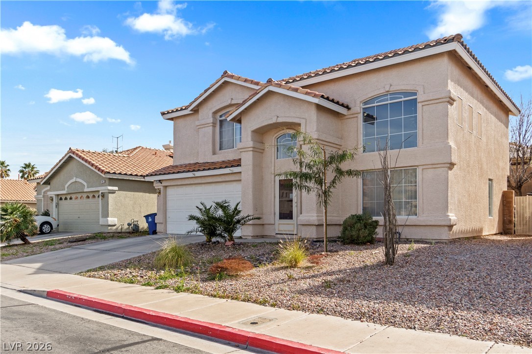 1419 Red Sunset Avenue Henderson, NV 89074 - Photo 4 of 35 Mediterranean / spanish house featuring driveway, an attached garage, and stucco siding
