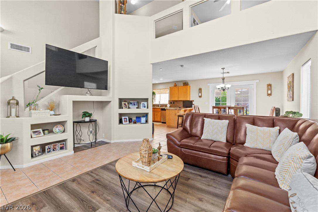 1419 Red Sunset Avenue Henderson, NV 89074 - Photo 8 of 35 Living area featuring light wood-style flooring, built in features, suspended lighting, and a high ceiling