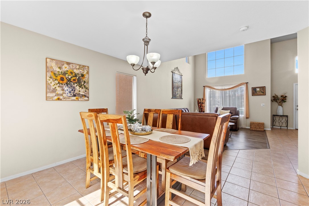 1419 Red Sunset Avenue Henderson, NV 89074 - Photo 9 of 35 Dining space featuring light tile patterned floors, hanging lights, and a high ceiling