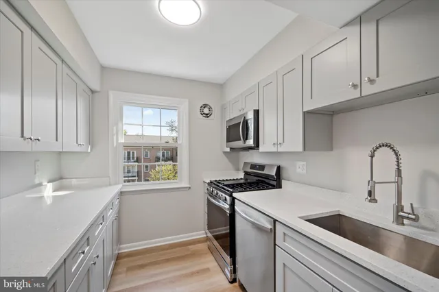 a kitchen with stainless steel appliances granite countertop a sink stove and cabinets