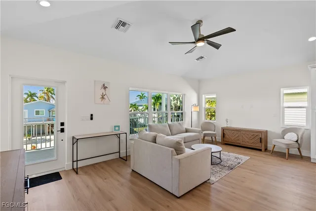 a kitchen with a refrigerator a stove top oven a sink dishwasher and white cabinets with wooden floor