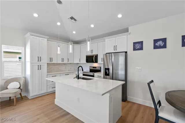 a kitchen with stainless steel appliances a refrigerator a sink a stove a microwave and island