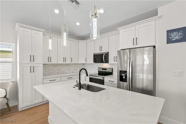 a kitchen with granite countertop a refrigerator stove and sink