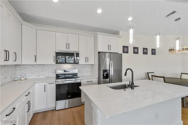 a kitchen with granite countertop white cabinets and stainless steel appliances