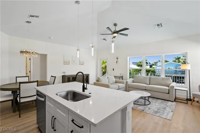 a kitchen with stainless steel appliances a sink a stove a table and chairs