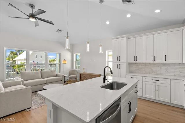 a kitchen with stainless steel appliances granite countertop a sink a stove a refrigerator and a microwave with wooden floor