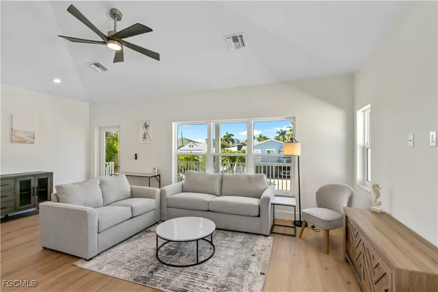 a living room with stainless steel appliances kitchen island furniture and a wooden floor