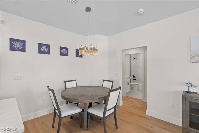 a living room with stainless steel appliances furniture a dining table and kitchen view