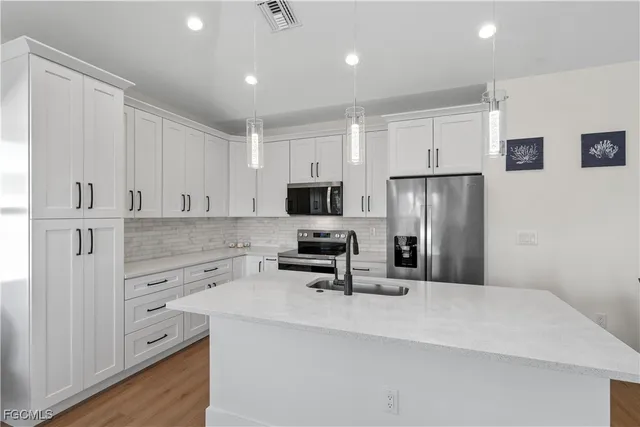 a kitchen with white cabinets and stainless steel appliances