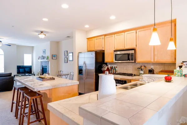 a kitchen with stainless steel appliances kitchen island granite countertop a sink stove and refrigerator