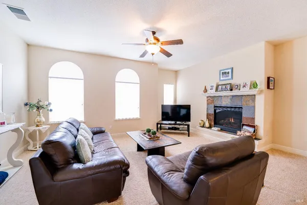 a living room with furniture a fireplace and a chandelier