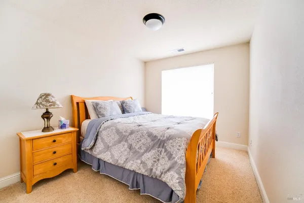 a bed sitting in a bedroom next to a window
