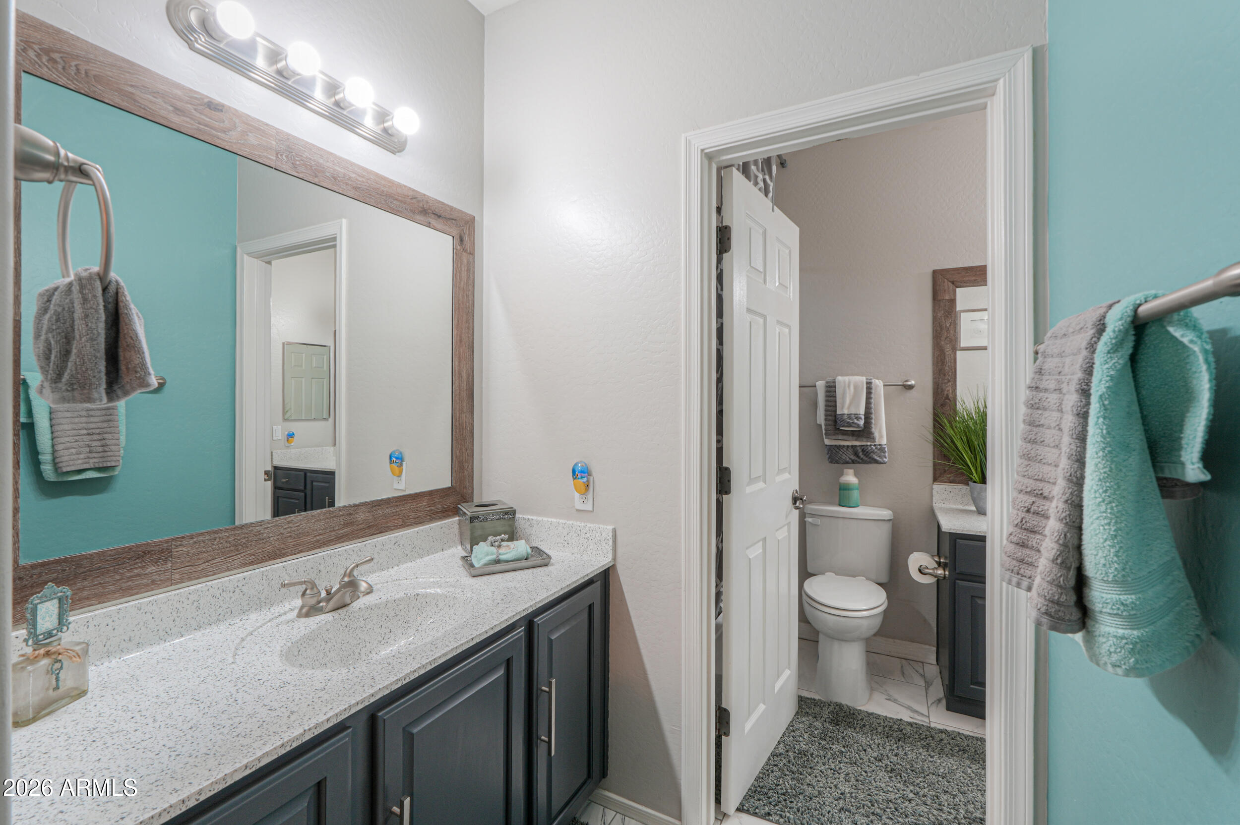 45247 West Jack Rabbit Trail Maricopa, AZ 85139 - Photo 36 of 75 a bathroom with a granite countertop sink a toilet and a mirror
