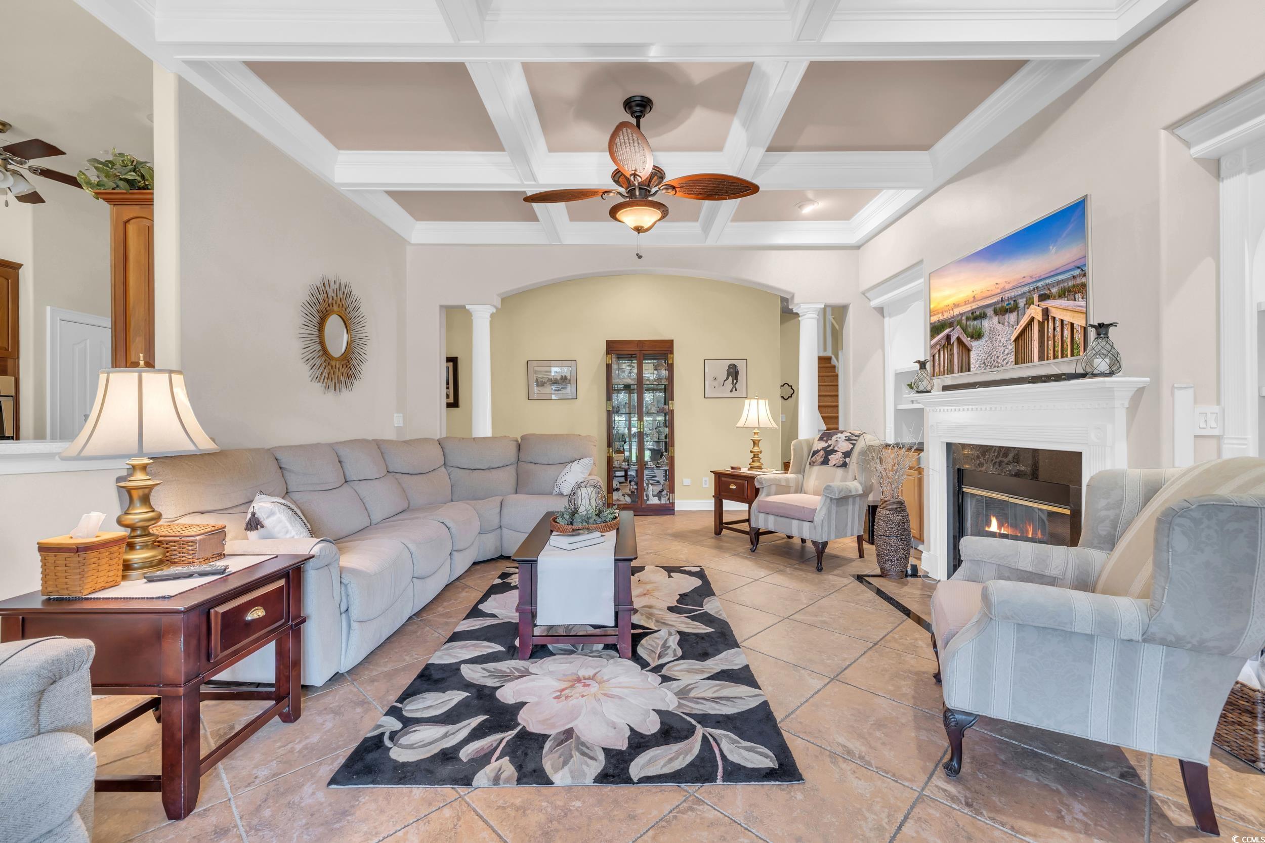 4254 Congressional Drive Myrtle Beach, SC 29579 - Photo 16 of 40 Living room with ceiling fan, coffered ceiling, a wood burning fireplace, and tile floors