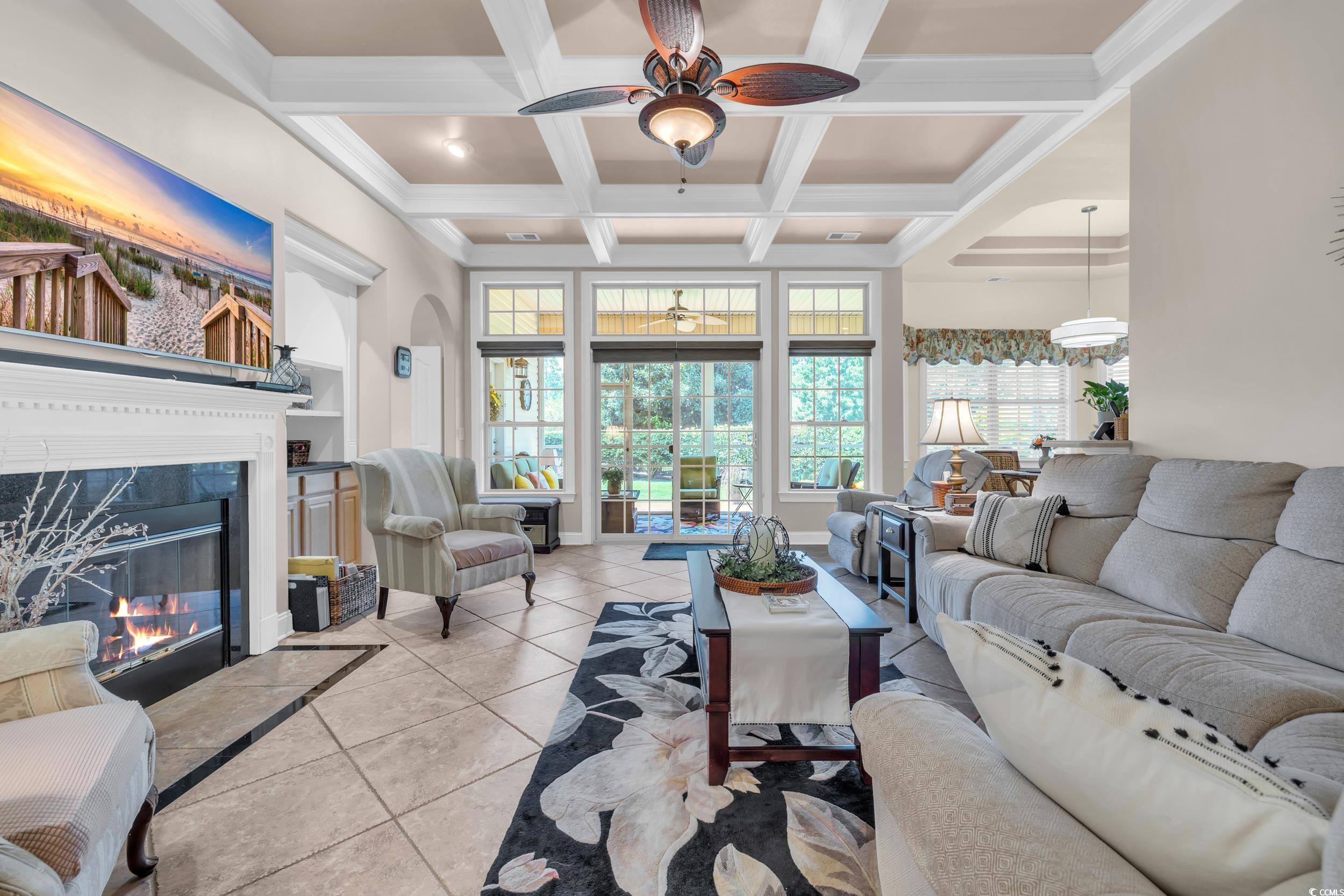 4254 Congressional Drive Myrtle Beach, SC 29579 - Photo 2 of 40 Living area featuring a wood burning fireplace, tile floors, built-ins, ceiling fan, and coffered ceiling