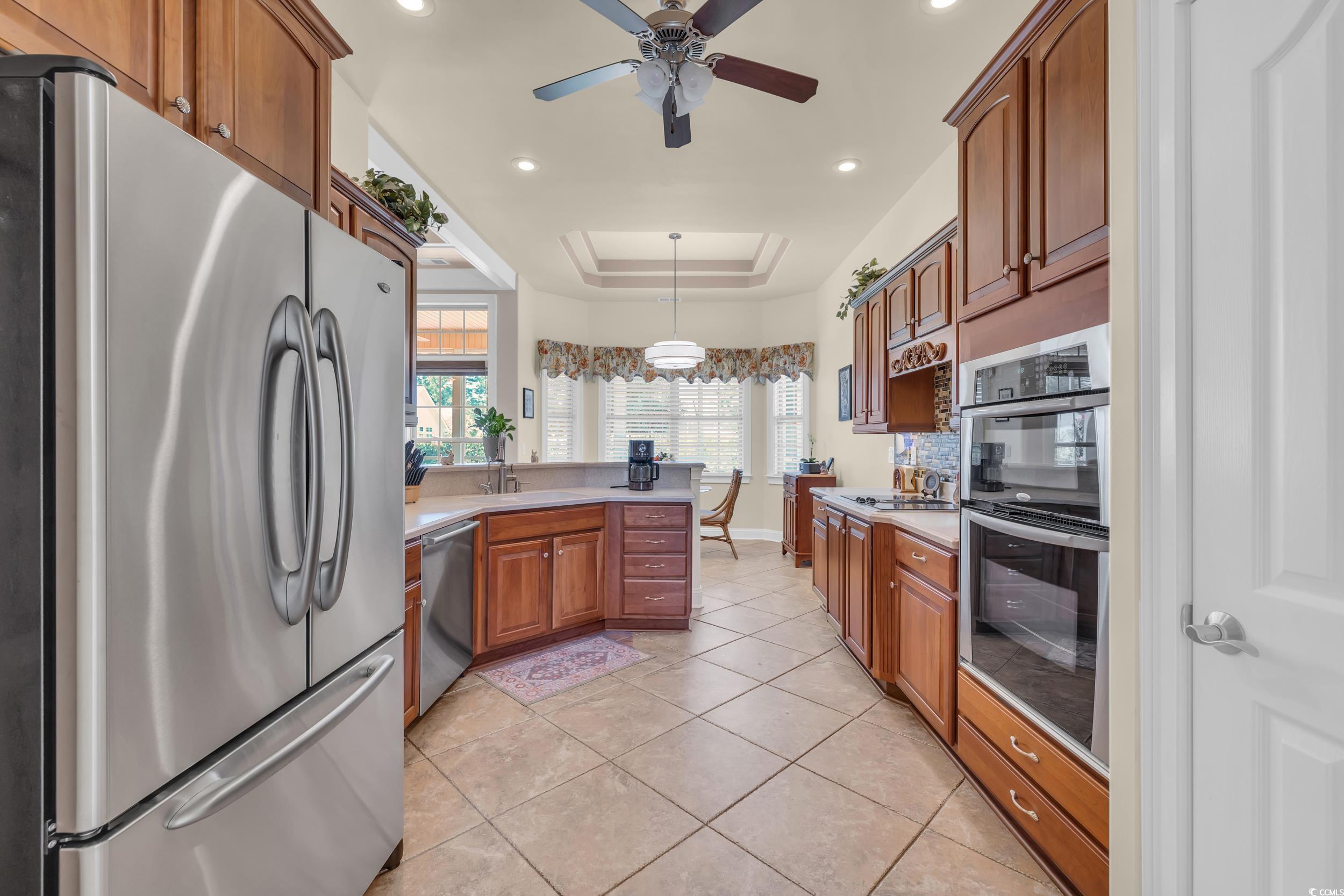 4254 Congressional Drive Myrtle Beach, SC 29579 - Photo 3 of 40 Kitchen featuring stainless steel appliances, a tray ceiling, pendant lighting, tile floors, and a peninsula