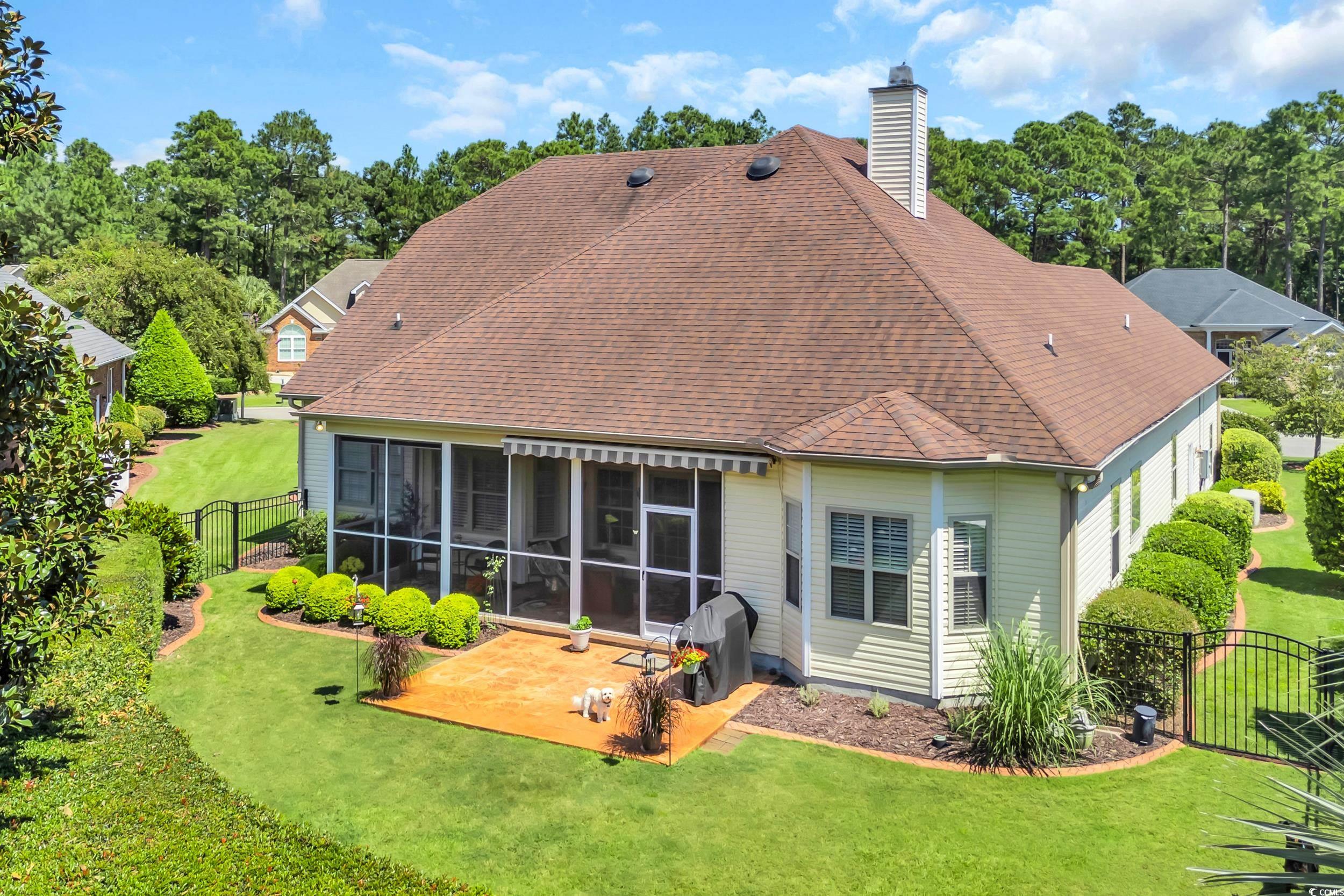 4254 Congressional Drive Myrtle Beach, SC 29579 - Photo 32 of 40 Back of property featuring a fenced backyard, a chimney, roof with shingles, a screened porch and privacy shrubs