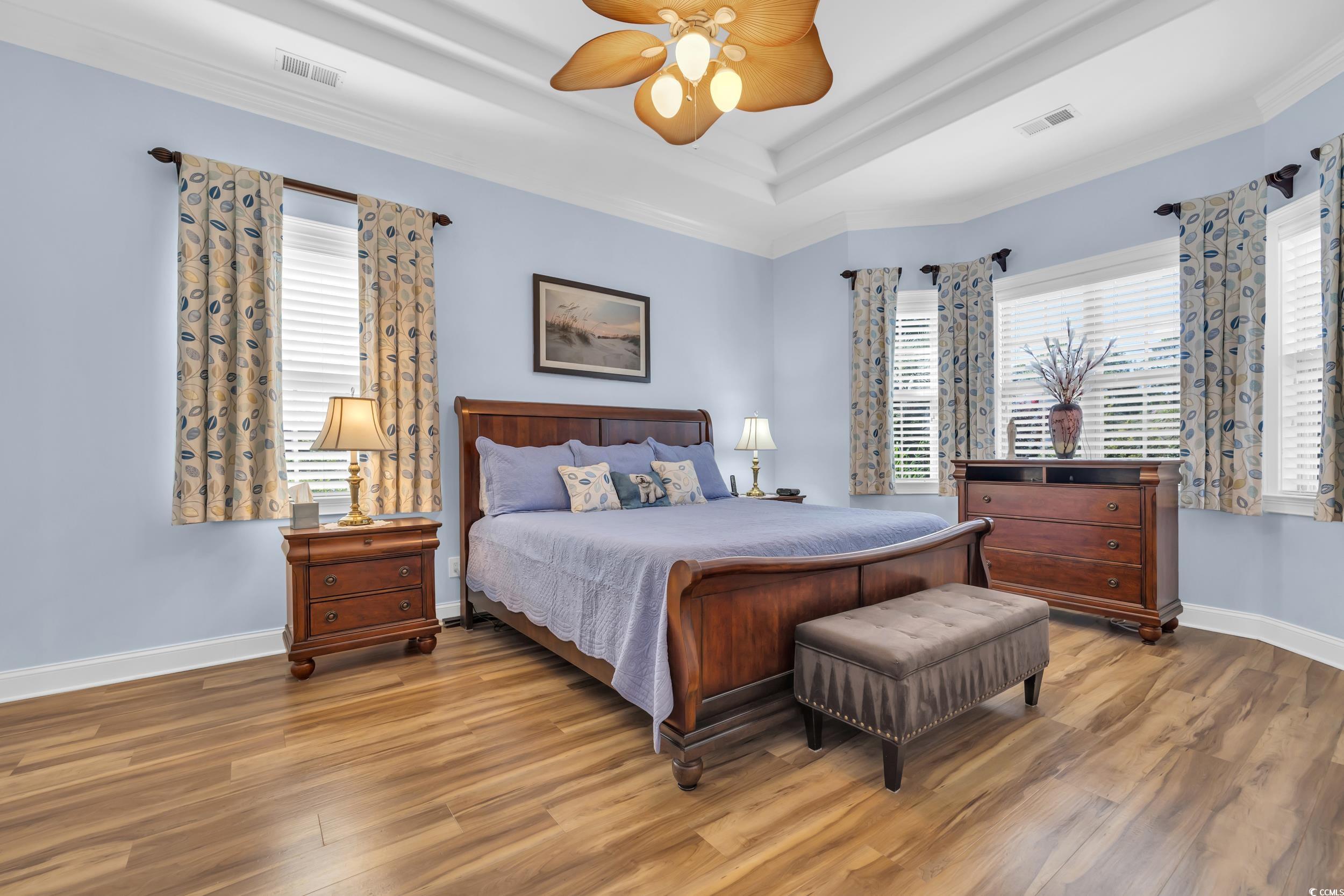 4254 Congressional Drive Myrtle Beach, SC 29579 - Photo 5 of 40 Bedroom featuring LVP floors, multiple windows, ceiling fan, and a tray ceiling