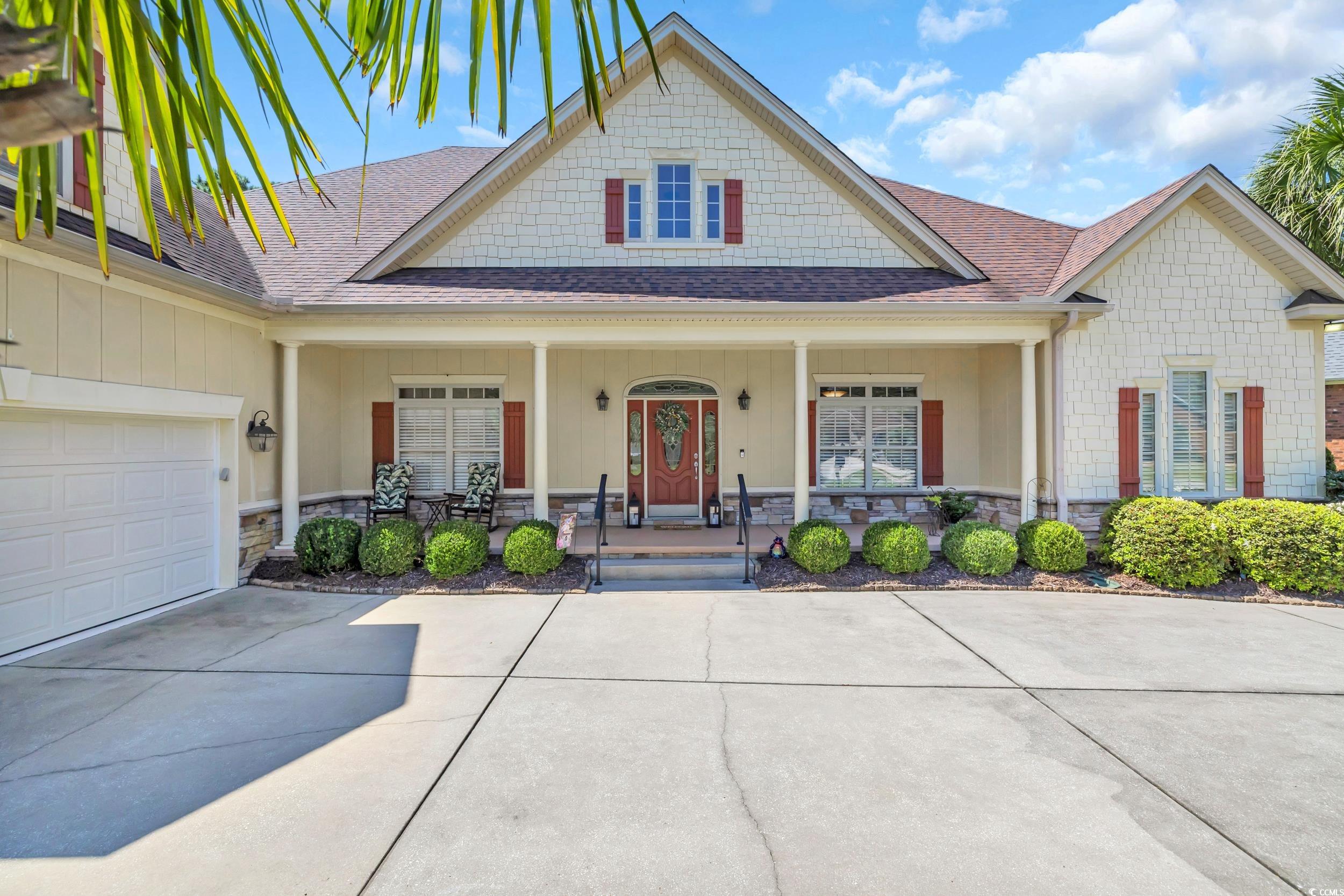 4254 Congressional Drive Myrtle Beach, SC 29579 - Photo 8 of 40 View of front of property with roof with shingles, stone siding, covered porch, a garage, and concrete driveway
