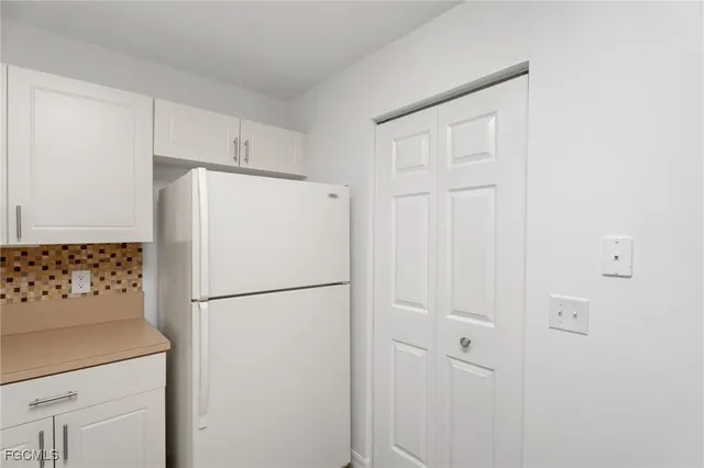 a white refrigerator freezer and a stove sitting inside of a kitchen