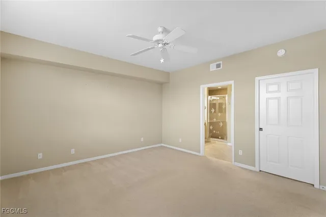 an empty room with a ceiling fan and a window