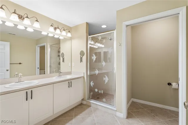a bathroom with a double vanity sink mirror and shower
