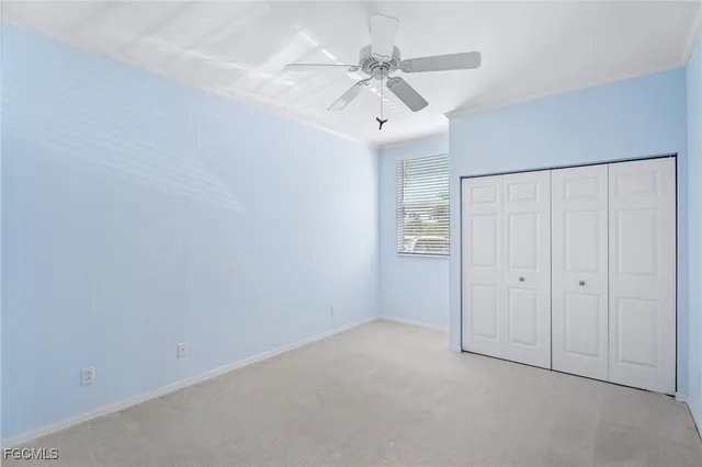 an empty room with a ceiling fan and a window