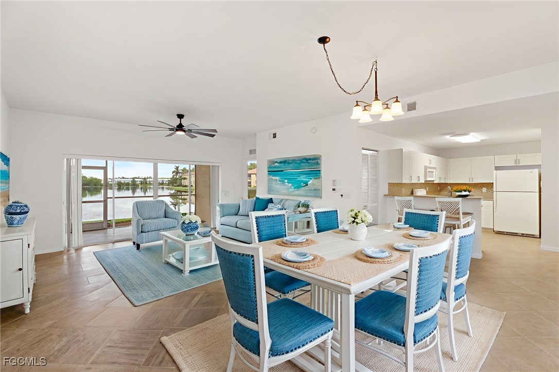 4336 Bellasol Circle, Unit 2911 Fort Myers, FL 33916 - Photo 6 of 45 a view of a dining room with furniture wooden floor and chandelier