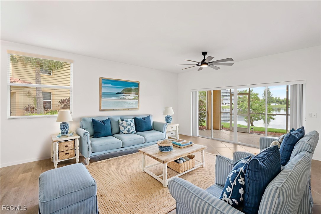 4336 Bellasol Circle, Unit 2911 Fort Myers, FL 33916 - Photo 8 of 45 a living room with furniture a large window and a chandelier