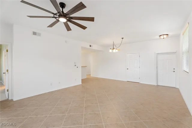 en empty room with ceiling fan and window