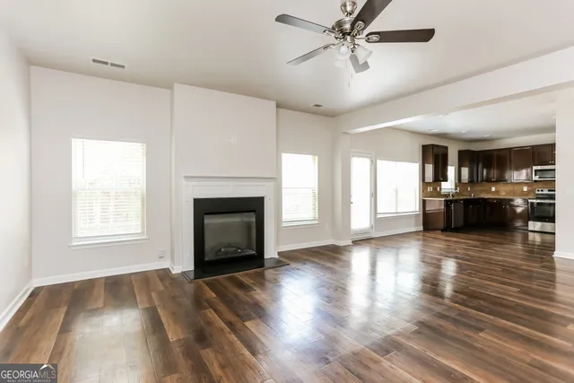 wooden floor fireplace and windows in an empty room
