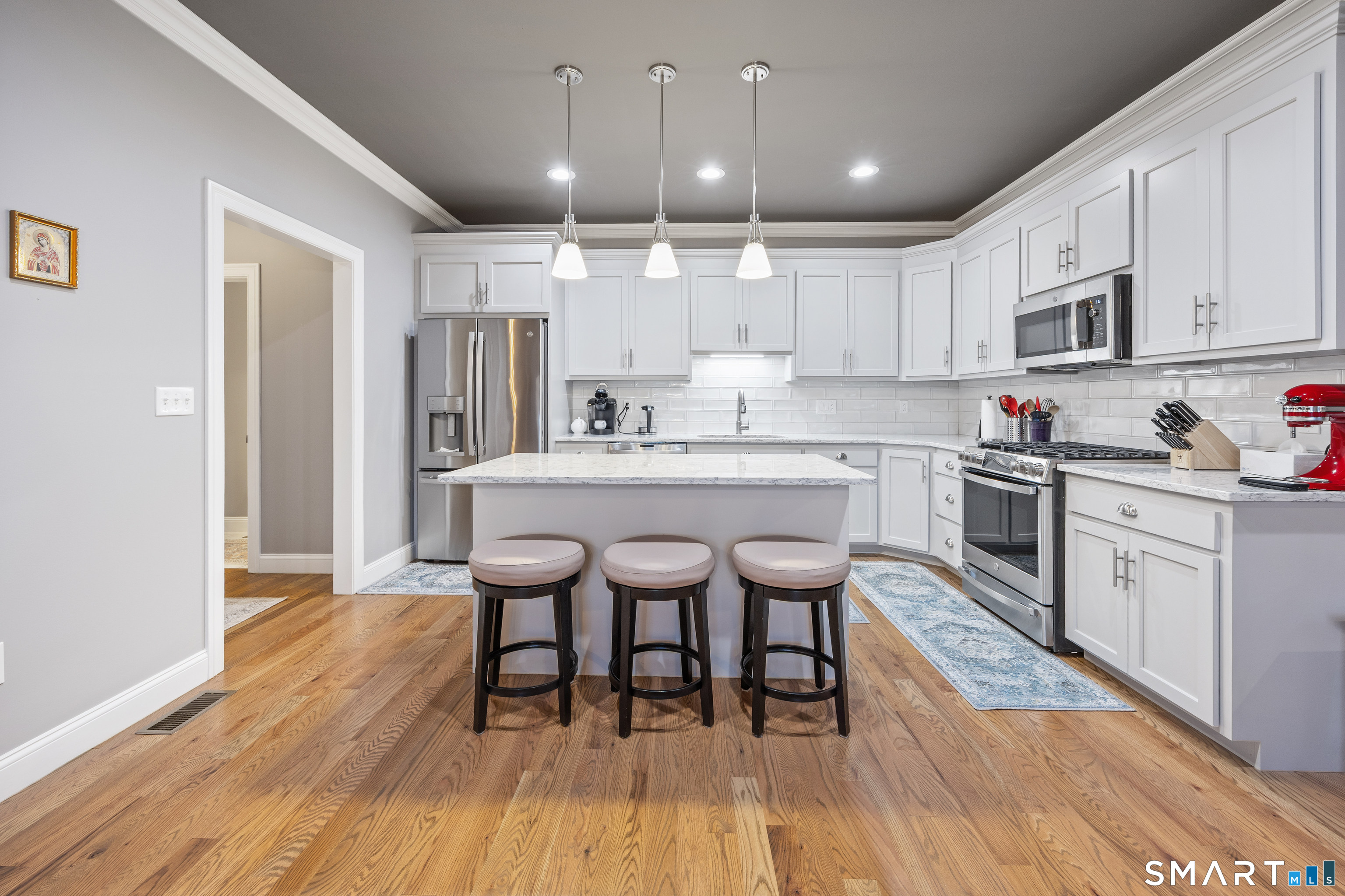 52 Brookview Circle, Unit 52 Bristol, CT 06010 - Photo 7 of 29 a kitchen with a dining table chairs wooden floor cabinets and appliances