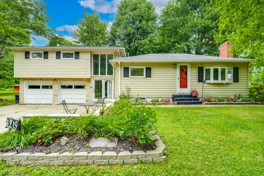 View of front of property featuring a garage and a front yard