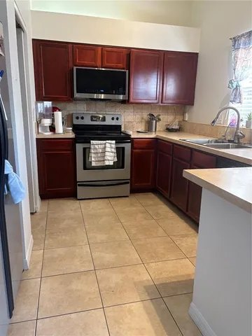 a kitchen with a sink a stove and a microwave