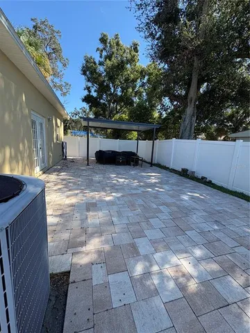 a view of backyard with large trees and wooden fence