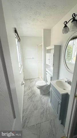 a white toilet sitting next to a bathroom sink