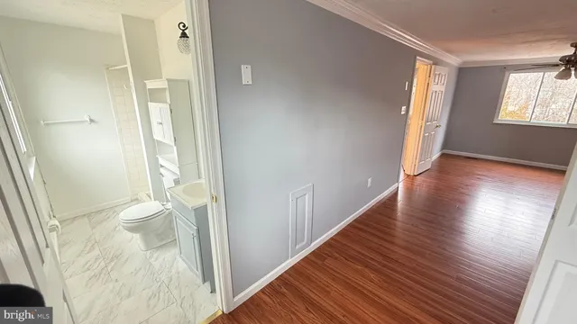 a view of empty room with wooden floor