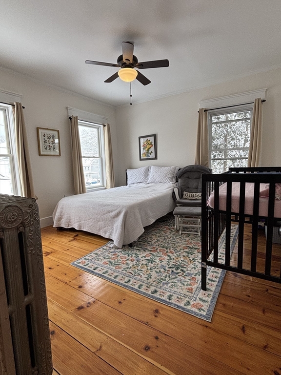 142 Sanders Avenue Lowell, MA 01851 - Photo 19 of 28 a bedroom with a bed and wooden floor