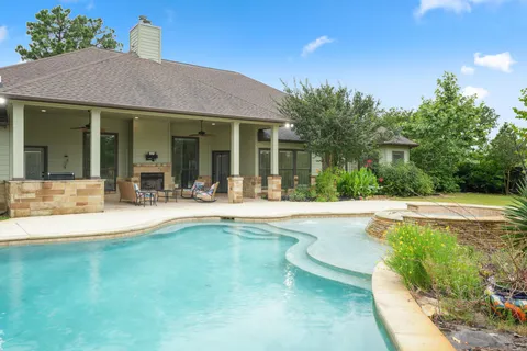 a view of a house with swimming pool and a porch with furniture