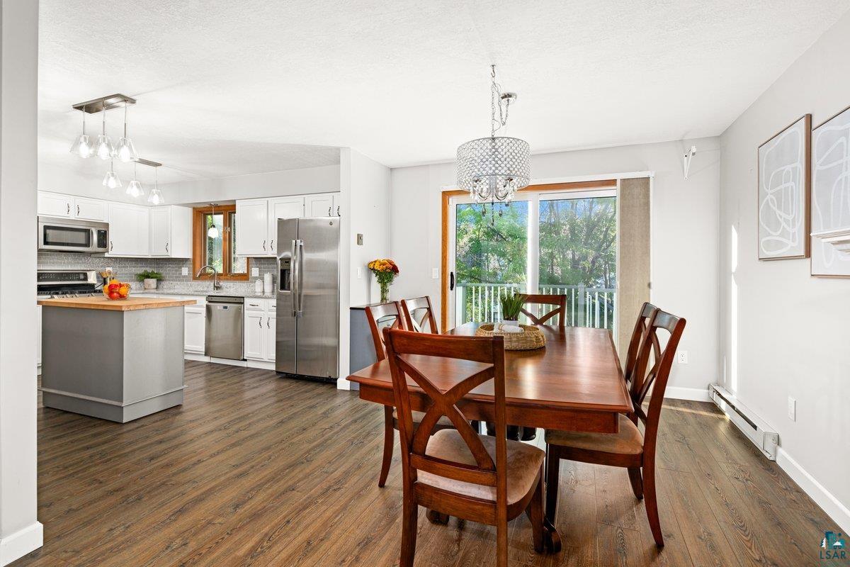 2524 Providence Road Duluth, MN 55811 - Photo 11 of 42 Dining room featuring a textured ceiling, a baseboard radiator, dark hardwood / wood-style floors, sink, and a notable chandelier
