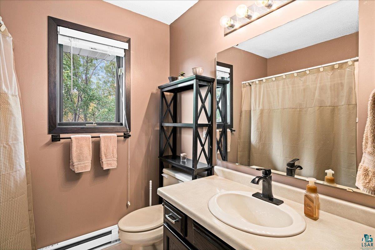 2524 Providence Road Duluth, MN 55811 - Photo 23 of 42 Bathroom with toilet, baseboard heating, and vanity