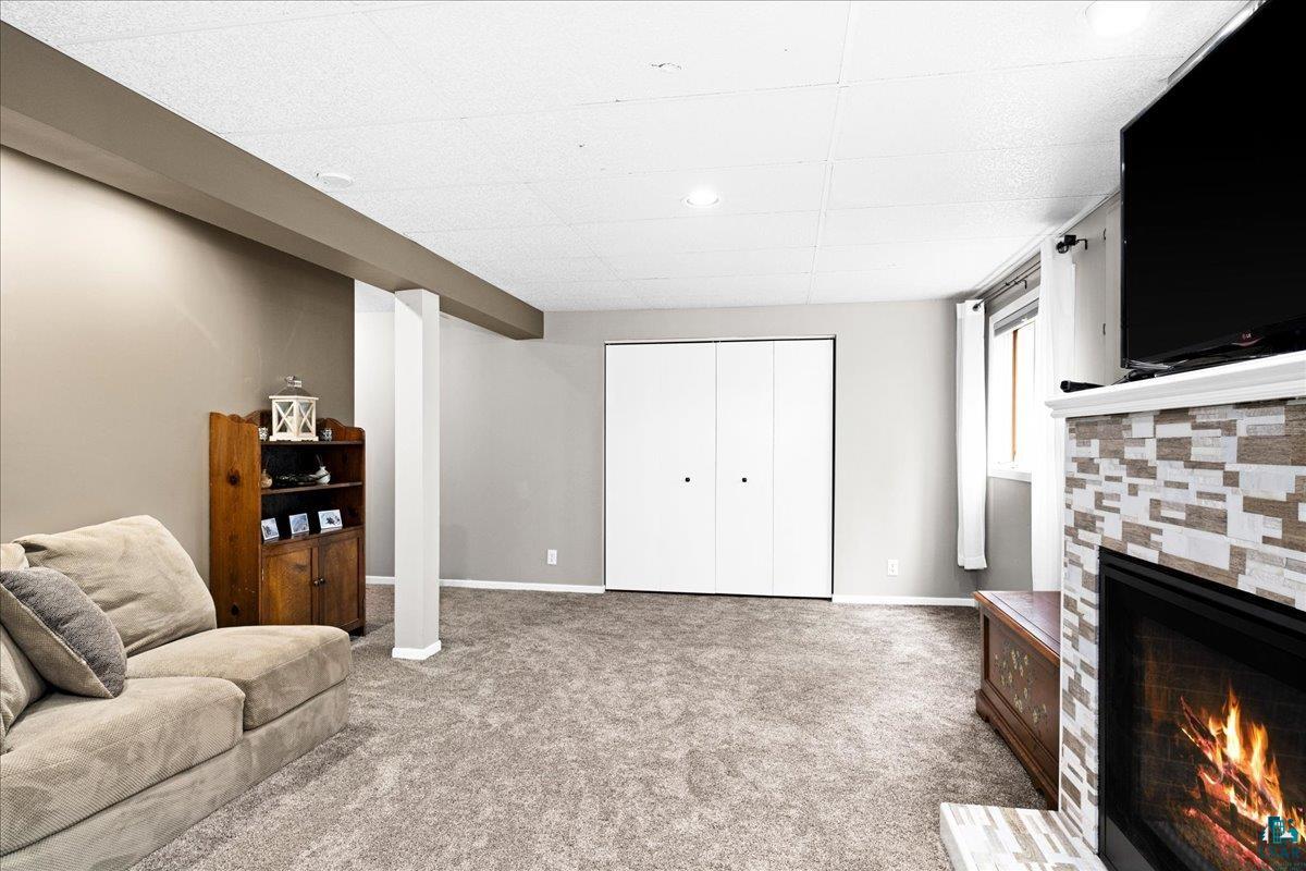 2524 Providence Road Duluth, MN 55811 - Photo 25 of 42 Carpeted living room with a tile fireplace