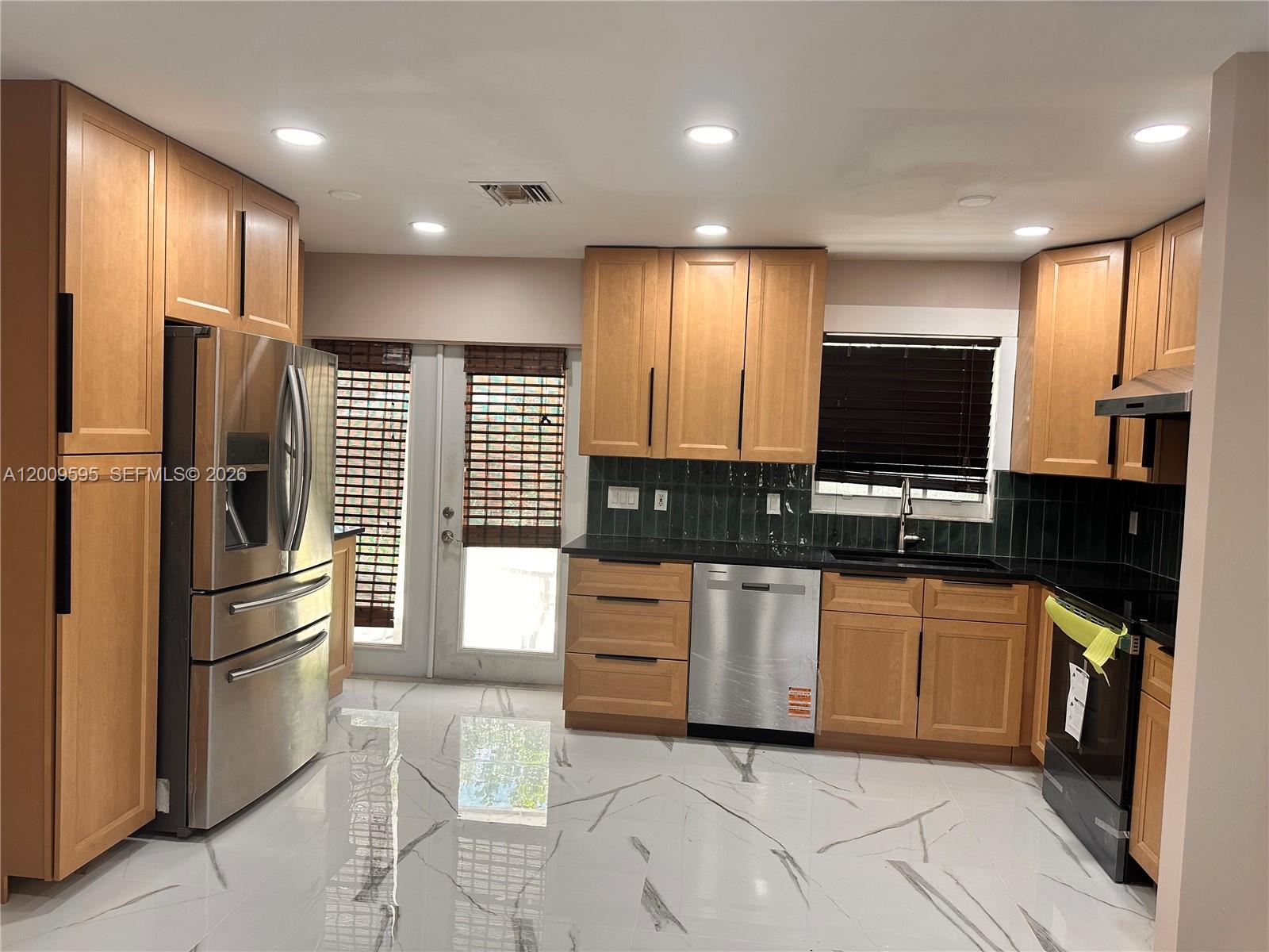 3614 Everglades Road Palm Beach Gardens, FL 33410 - Photo 1 of 9 a kitchen with stainless steel appliances granite countertop a refrigerator and a stove top oven