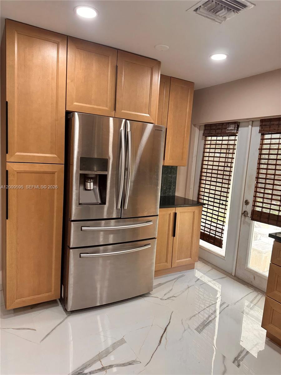 3614 Everglades Road Palm Beach Gardens, FL 33410 - Photo 3 of 9 a metallic refrigerator freezer sitting in a kitchen